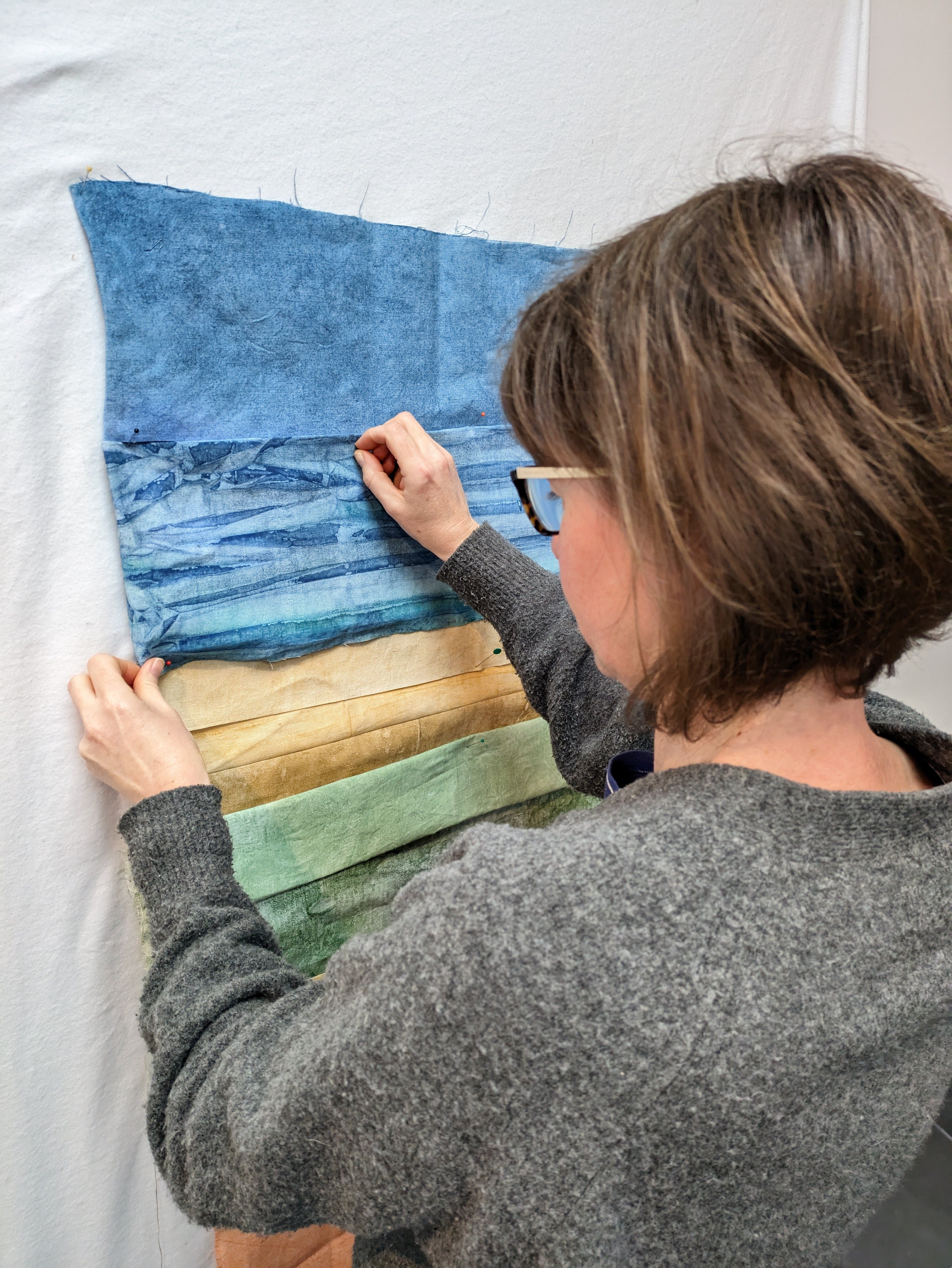 Artist arranging textile artwork