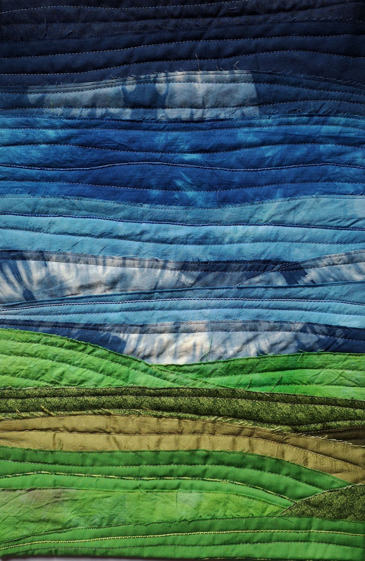 Textile landscape with blue sky and green fields